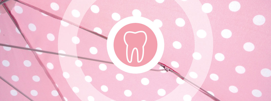 Ein rosa Schirm mit weißen Punkten als Symbol für das wichtige Zusammenspiel von Zähnen und Zahnfleisch.